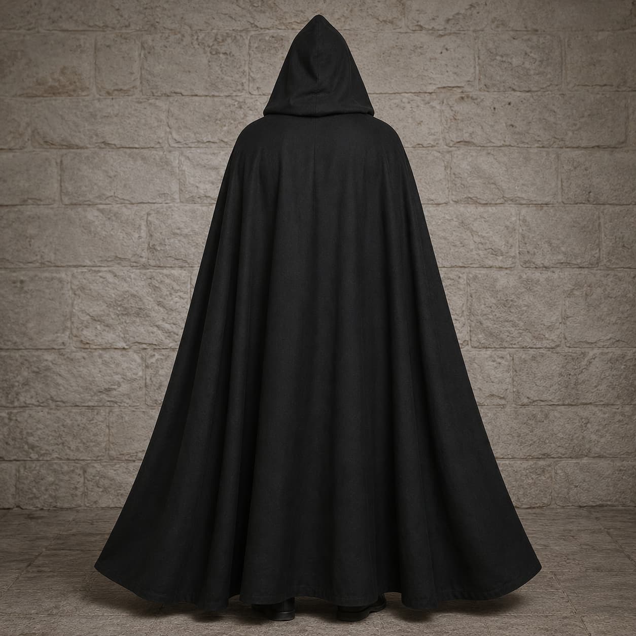 Vue arrière de la Cape de la Confrérie Templière en nylon noir sur fond de pierre médiévale claire.