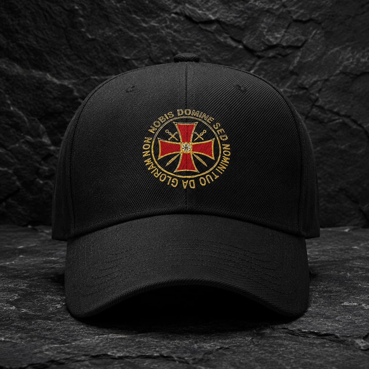 Casquette Non Nobis noire en polyester et coton avec emblème templier rouge et doré sur pierre sombre.