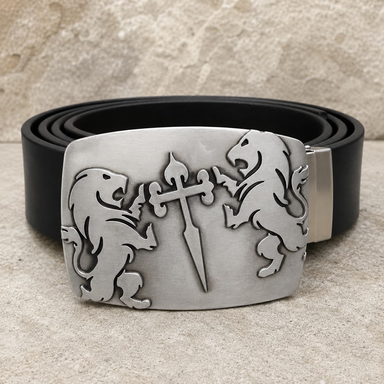 Ceinture Cœur de Lion en cuir noir avec boucle argentée en alliage de zinc ornée de deux lions et d’une épée sur fond pierre claire.