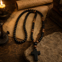 Chapelet du Moine en perles de pierre naturelle et bois présenté dans une ambiance médiévale avec parchemin, bois ancien et lumière chaude