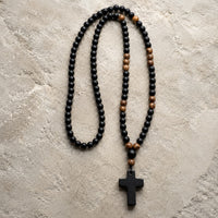 Chapelet du Moine en perles de pierre naturelle et bois avec croix noire sur pierre médiévale claire
