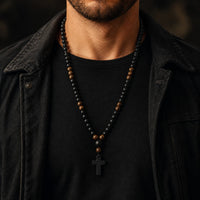 Homme portant le Chapelet du Moine en perles de pierre naturelle et bois avec tenue noire et veste sombre