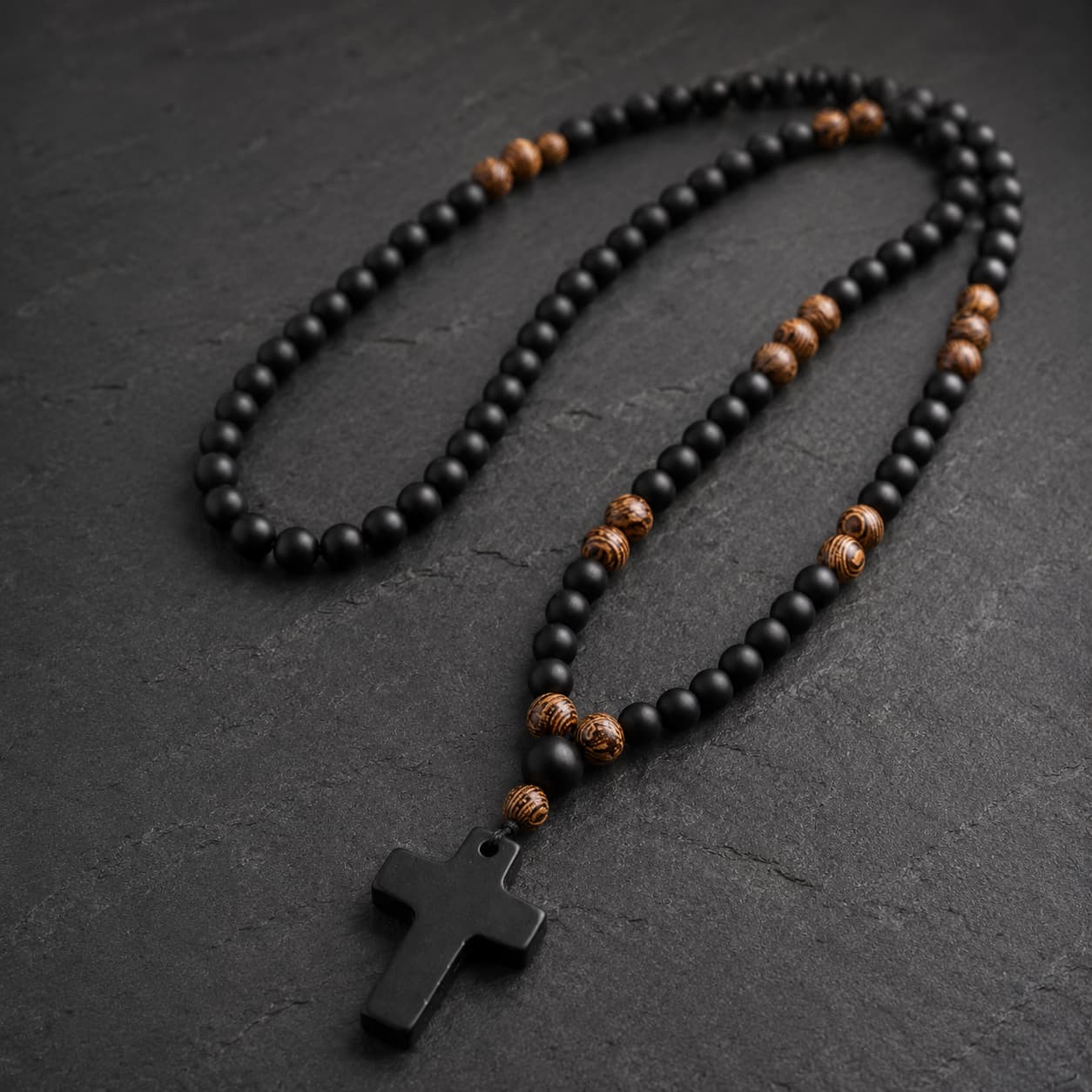 Vue angle du Chapelet du Moine en perles de pierre naturelle et bois sur fond anthracite texturé