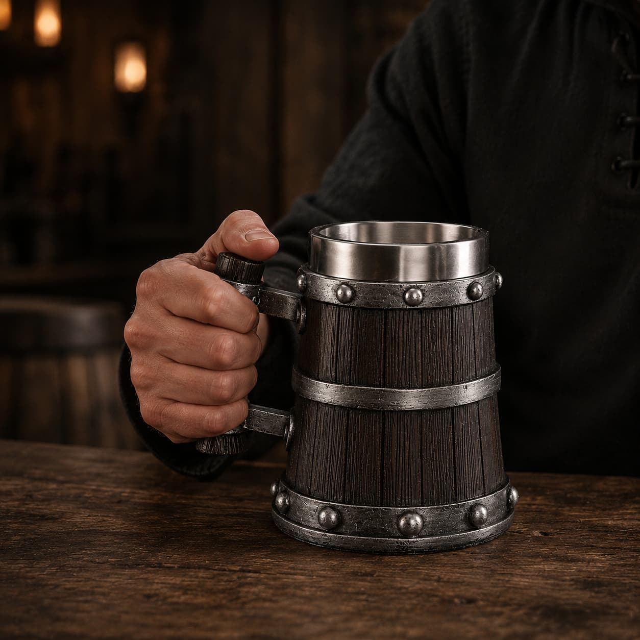 Homme tenant la Chope de Bière du Temple en résine avec intérieur en acier inoxydable dans une taverne sombre.