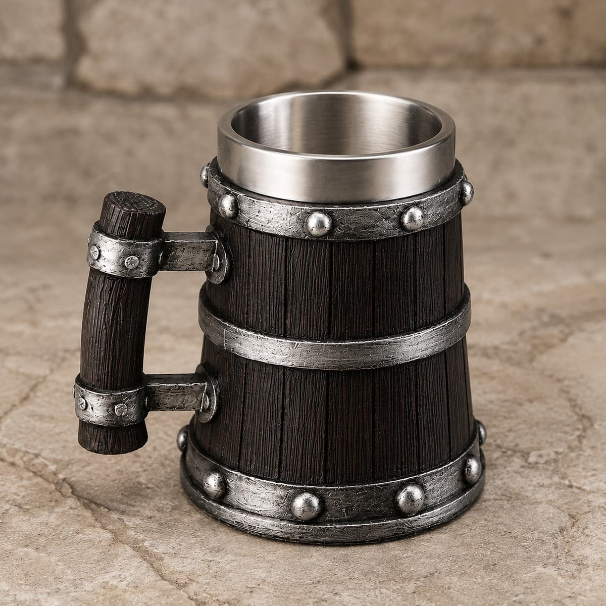 Chope de Bière du Temple en résine et acier inoxydable présentée en vue angle sur fond de pierre médiévale claire.