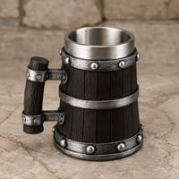 Chope de Bière du Temple en résine et acier inoxydable présentée en vue angle sur fond de pierre médiévale claire.