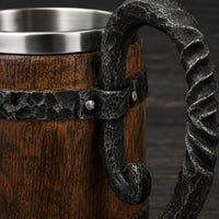 Gros plan sur la texture bois et les détails en métal forgé de la Chope de la Taverne.