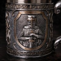 Gros plan sur le motif chevalier de la Chope du Festin Templier avec finition métal vieilli et détails sculptés.