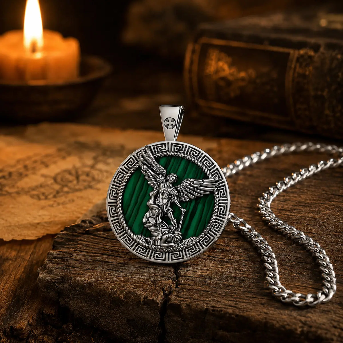 Collier Saint Michel en malachite dans une ambiance médiévale avec bougie et bois ancien
