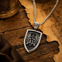 Collier de l’Archange Michel en acier inoxydable dans une ambiance médiévale avec bois ancien et parchemin