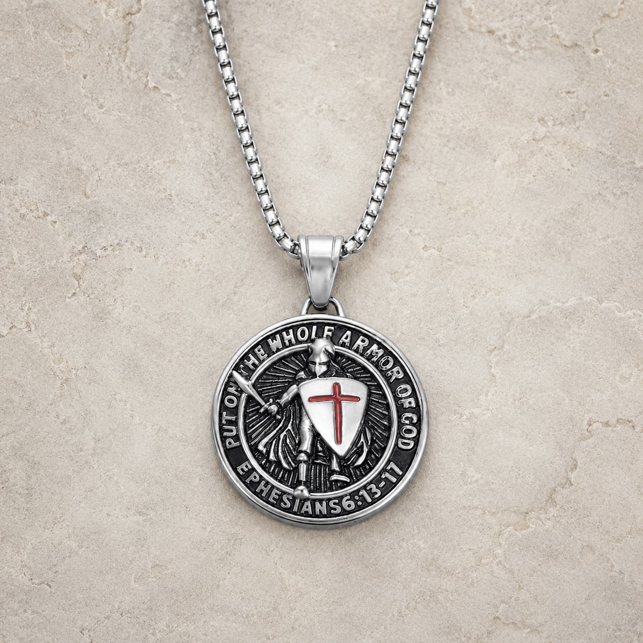 Variante argentée du Collier Armure du Templier en acier inoxydable sur fond pierre médiévale claire
