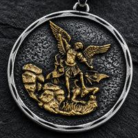 Gros plan du pendentif Bouclier de Saint Michel en acier inoxydable sur fond anthracite texturé ardoise sombre.