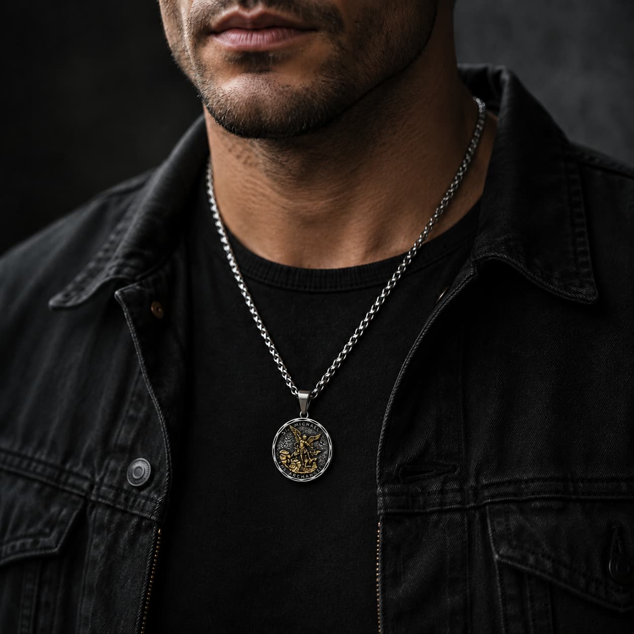 Collier Bouclier de Saint Michel en acier inoxydable porté par un homme en tenue noire dans une ambiance sombre.