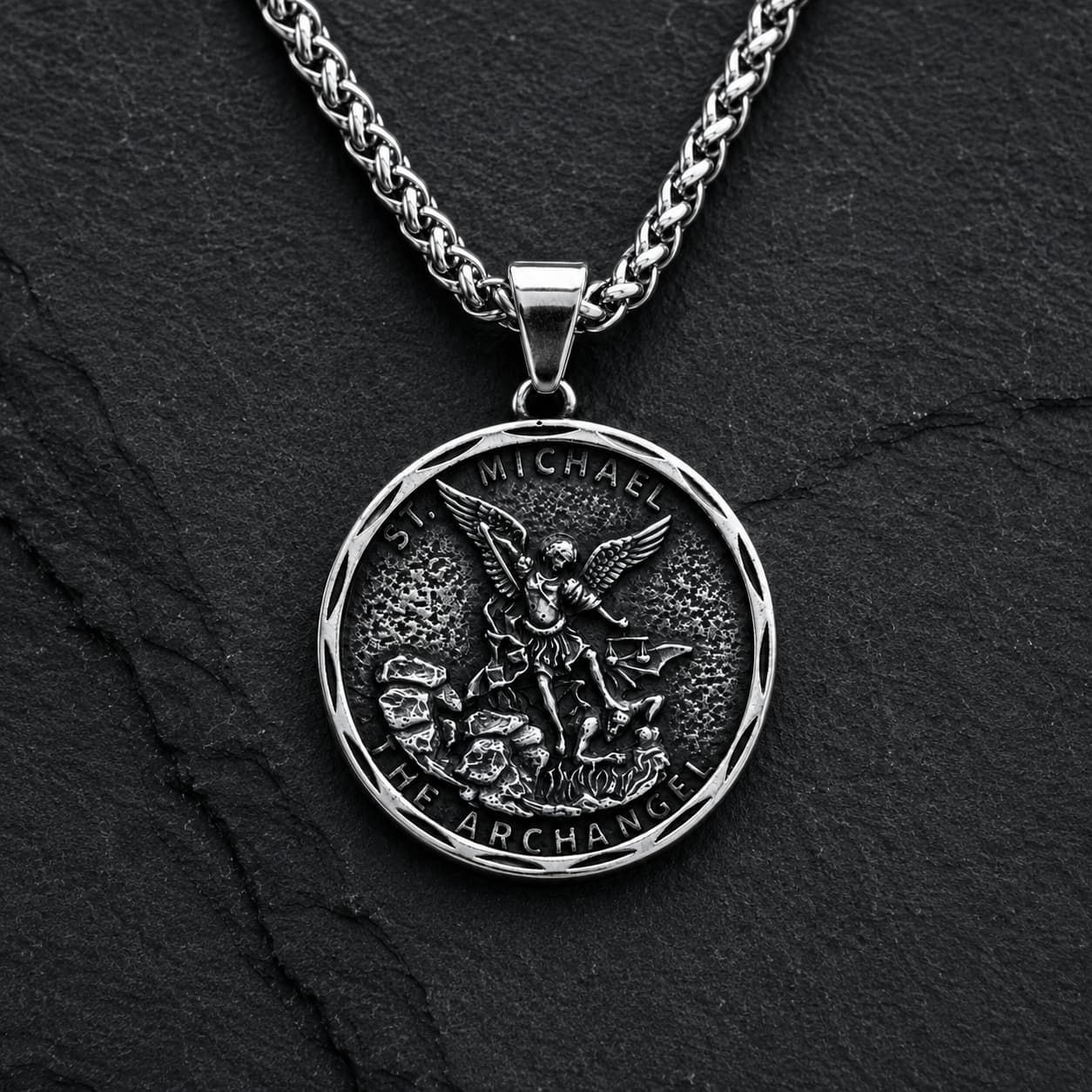Variante argent vieilli du Collier Bouclier de Saint Michel en acier inoxydable sur fond anthracite sombre.