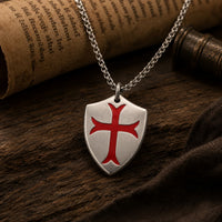 Collier de la Chevalerie en acier inoxydable dans une ambiance médiévale avec bois ancien et parchemin