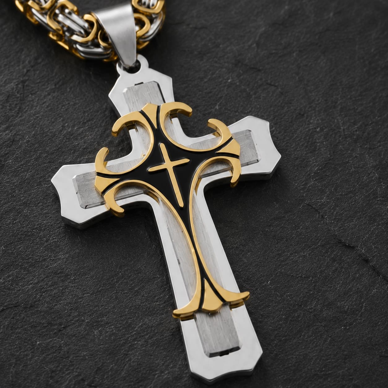 Gros plan du Collier Croisé de l’Espoir en acier inoxydable avec croix bicolore, détails dorés et fond noir