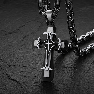 Collier Croisé de l’Espoir en acier inoxydable noir et argenté avec pendentif croix sur fond ardoise sombre