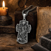 Collier Croix de l’Archange en alliage de zinc présenté dans une ambiance médiévale avec bois ancien et parchemin