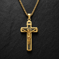 Variante dorée du Collier Croix de la Passion en acier inoxydable sur fond anthracite texturé.