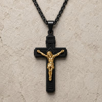 Variante noire du Collier Croix de la Passion en acier inoxydable avec Christ doré sur fond pierre médiévale claire.