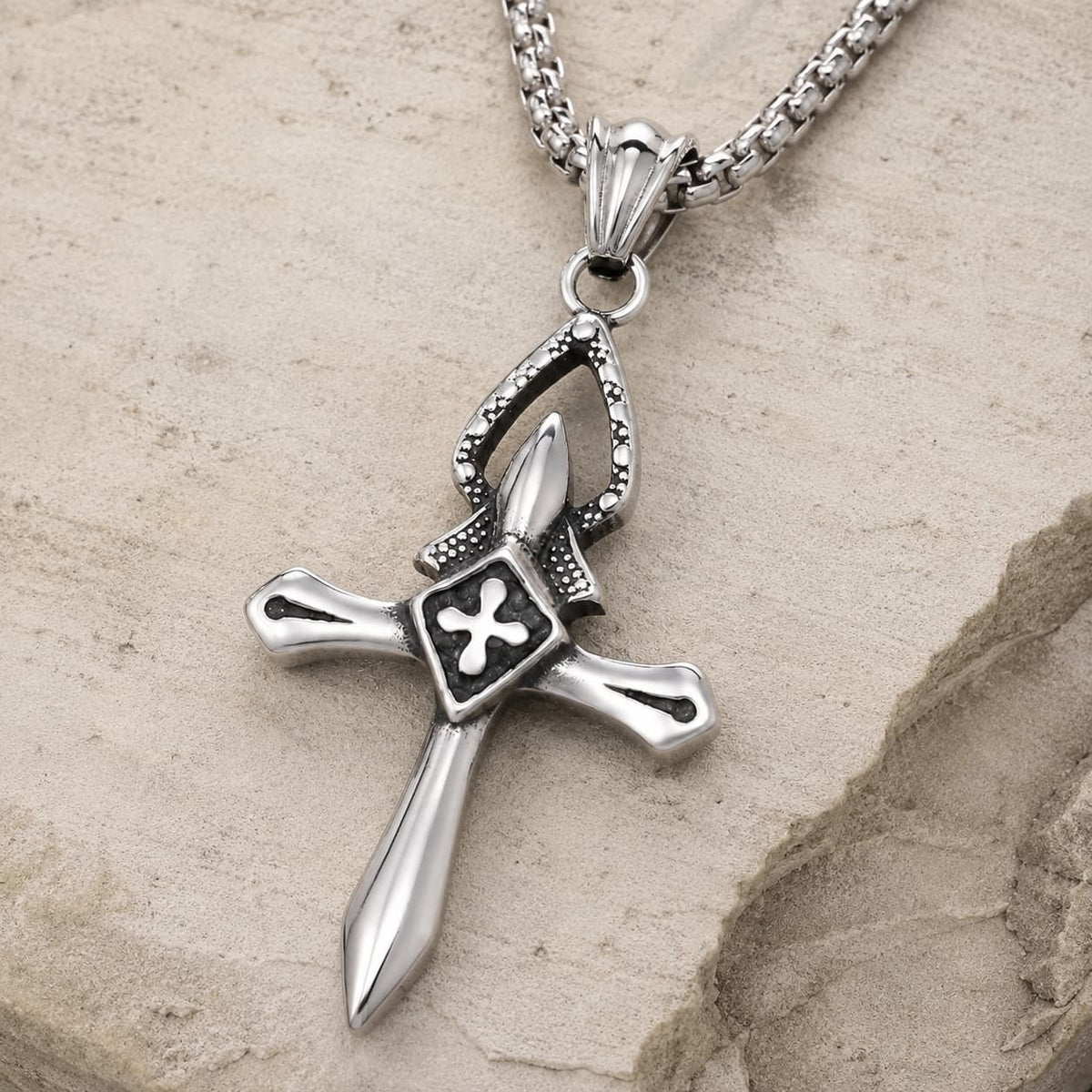 Collier Croix du Templier en acier inoxydable vue angle 3/4 sur pierre médiévale claire