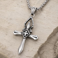 Collier Croix du Templier en acier inoxydable vue angle 3/4 sur pierre médiévale claire