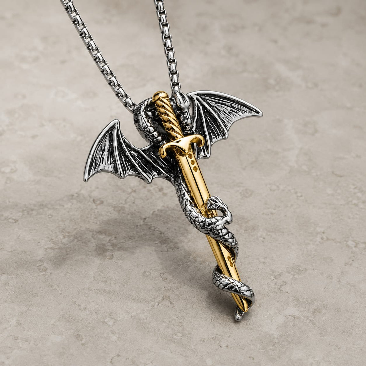 Collier de l’Épée du Croisé en acier inoxydable premium vue angle 3/4 sur pierre médiévale claire