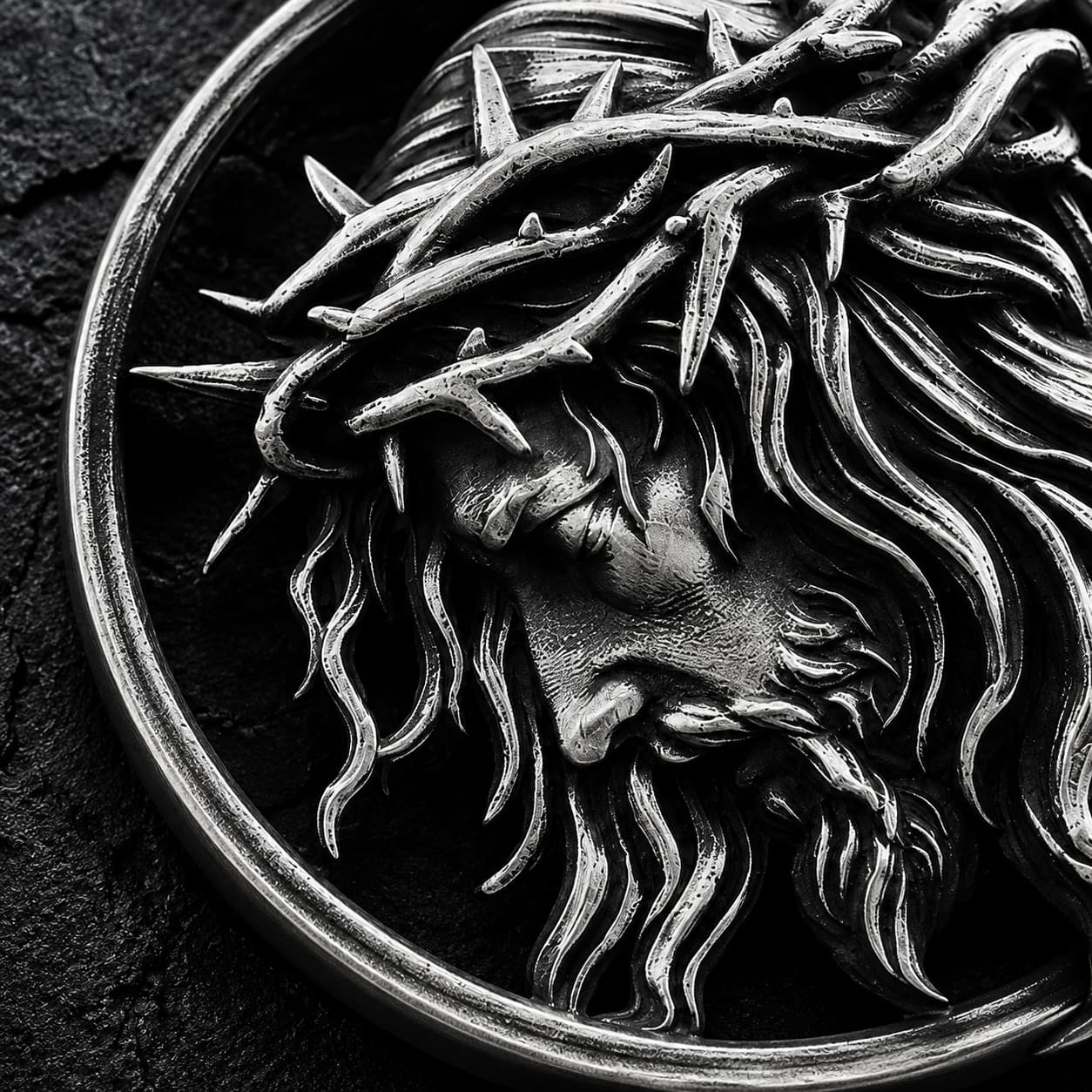 Gros plan du médaillon du Christ couronné d’épines du Collier de l’Espoir du Christ en acier inoxydable.