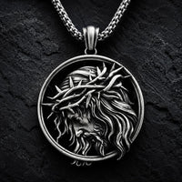 Collier de l’Espoir du Christ en acier inoxydable avec médaillon du Christ couronné d’épines sur fond anthracite texturé.