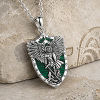 Vue angle du Collier de l’Illumination de l’Archange en argent 925 sterling avec pendentif bouclier vert sur pierre médiévale claire