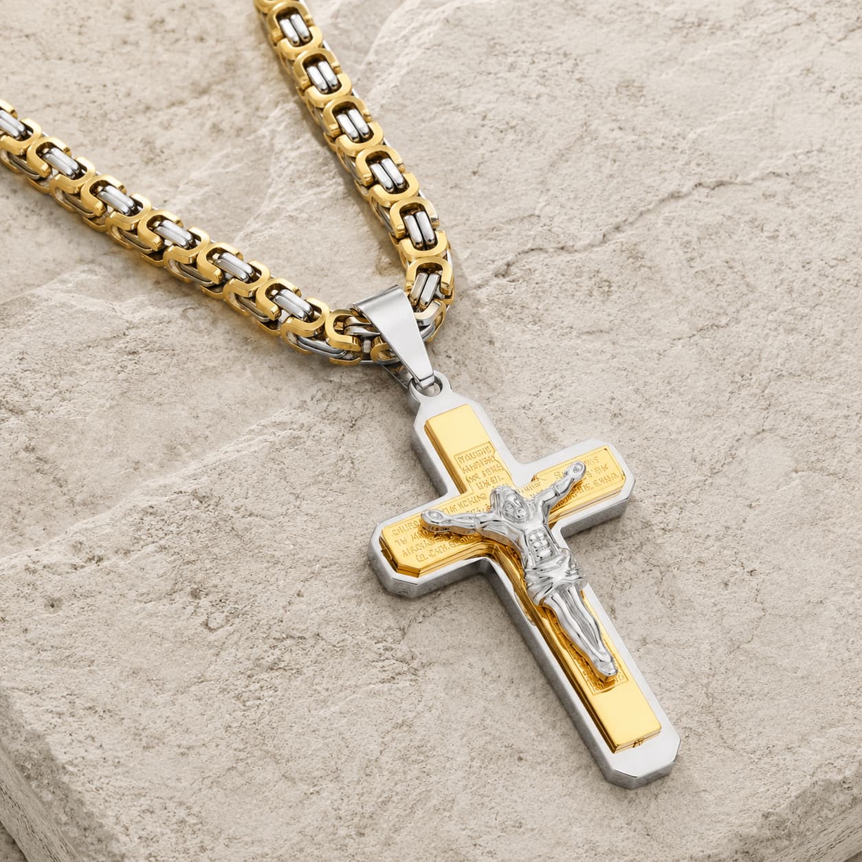 Collier de la Foi du Temple en acier inoxydable doré et argenté avec pendentif crucifix en vue angle 3/4 sur pierre médiévale claire