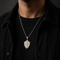Collier de la Sagesse Templière en acier inoxydable avec pendentif bouclier et croix dorée porté par un homme en tenue noire