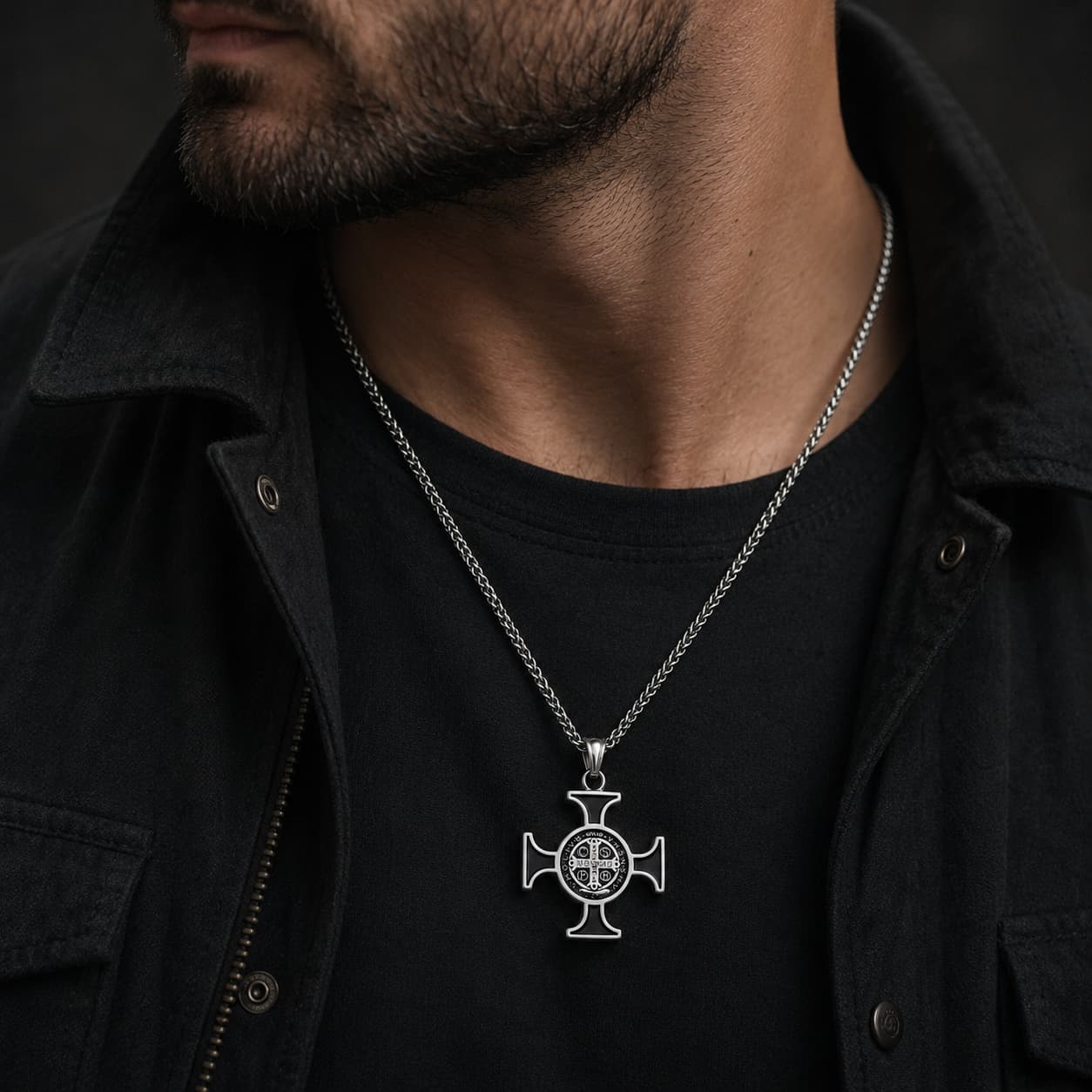 Homme portant le Collier de Saint Benoit en acier inoxydable avec veste noire et pendentif croix