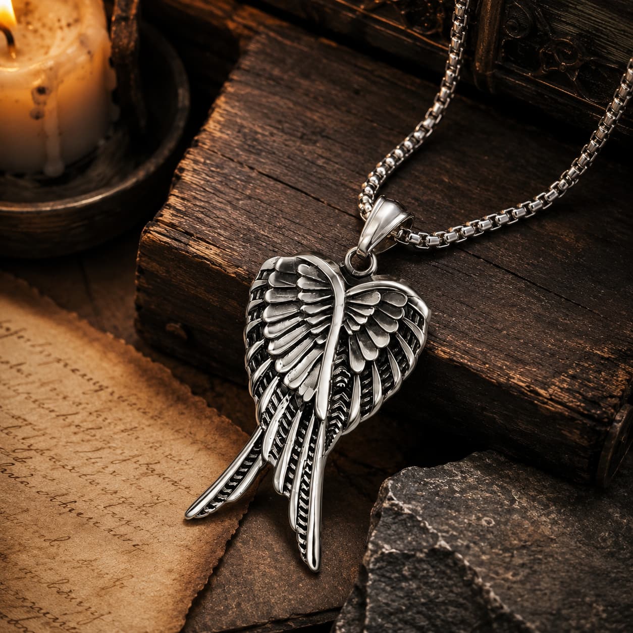 Collier des Ailes Célestes en acier inoxydable présenté dans une ambiance médiévale avec parchemin, bois ancien et lumière chaude
