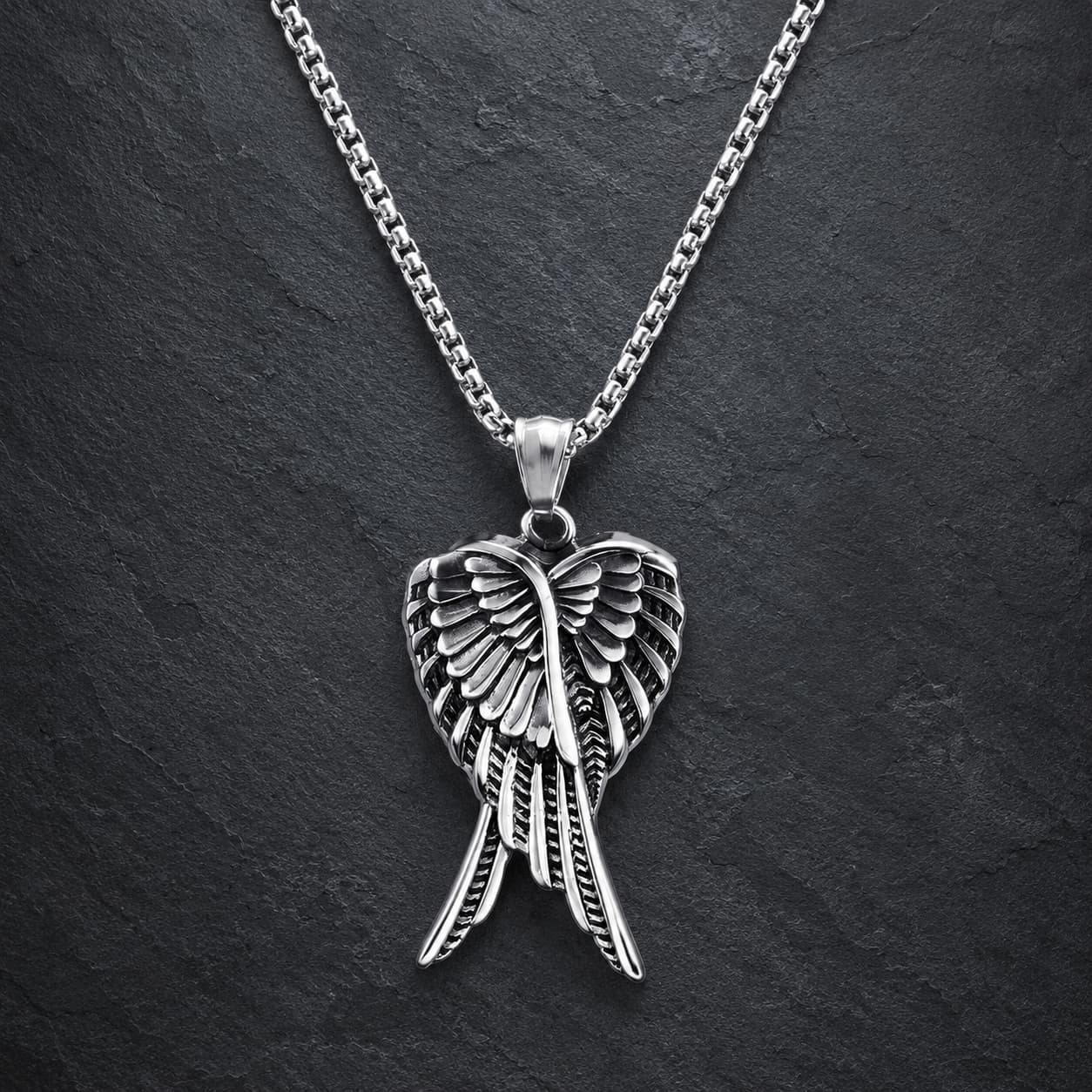 Collier des Ailes Célestes en acier inoxydable avec pendentif argenté sur fond anthracite