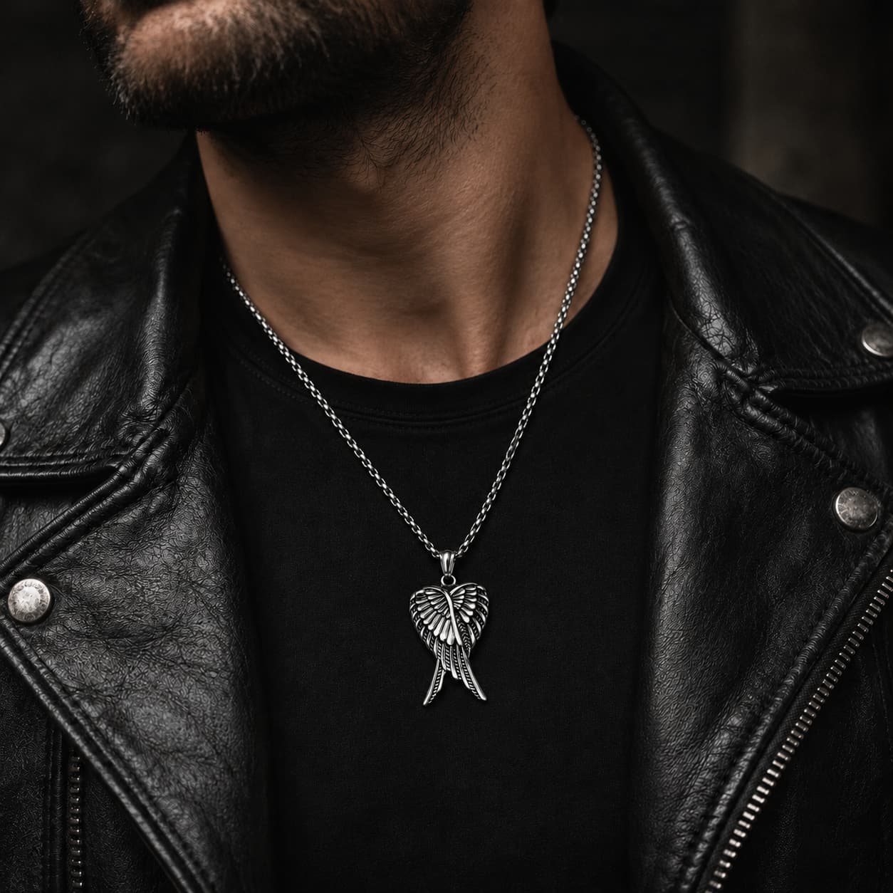 Homme portant le Collier des Ailes Célestes en acier inoxydable avec veste en cuir noir
