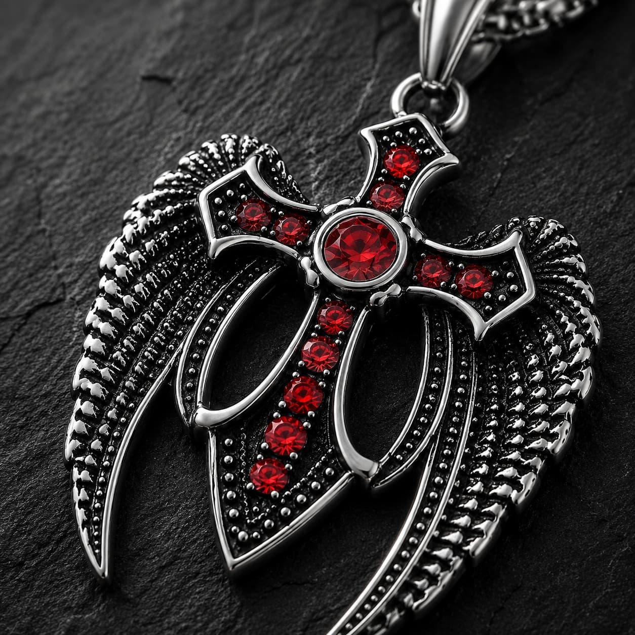 Gros plan du Collier des Ailes du Gardien en acier inoxydable avec croix ailée et pierres rouges