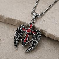 Vue angle du Collier des Ailes du Gardien en acier inoxydable avec pendentif croix ailée sur pierre médiévale claire