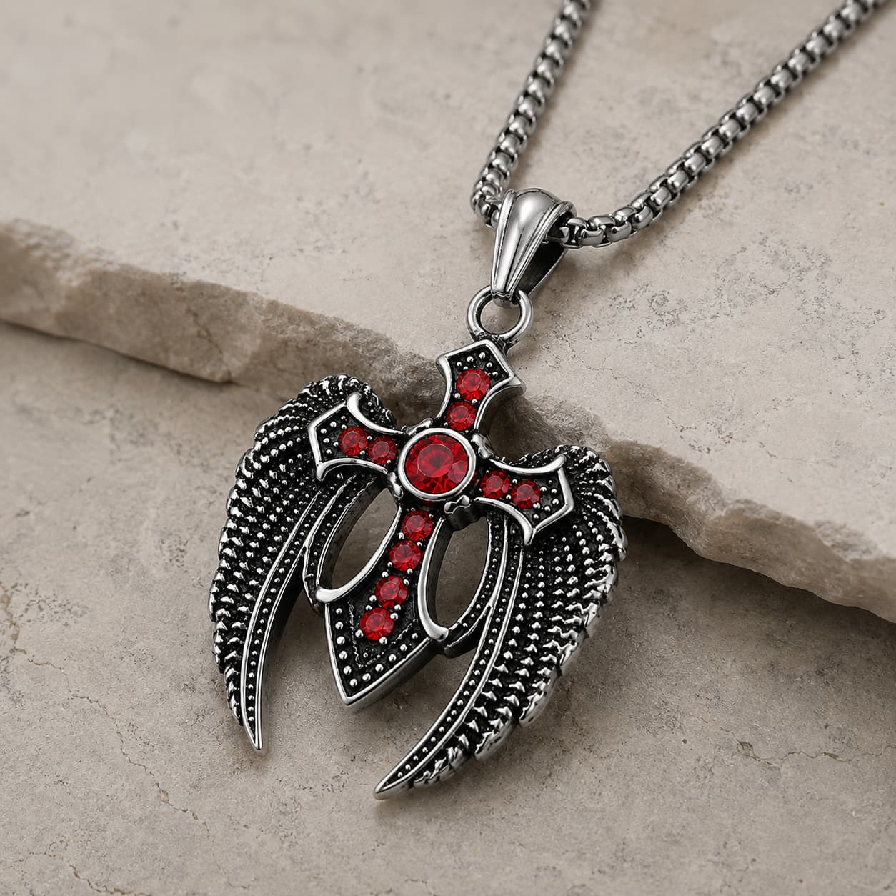 Vue angle du Collier des Ailes du Gardien en acier inoxydable avec pendentif croix ailée sur pierre médiévale claire