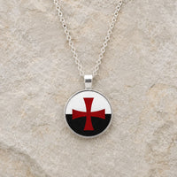 Collier des Emblèmes du Temple en alliage métallique avec pendentif rond croix rouge sur fond noir et blanc sur pierre médiévale claire