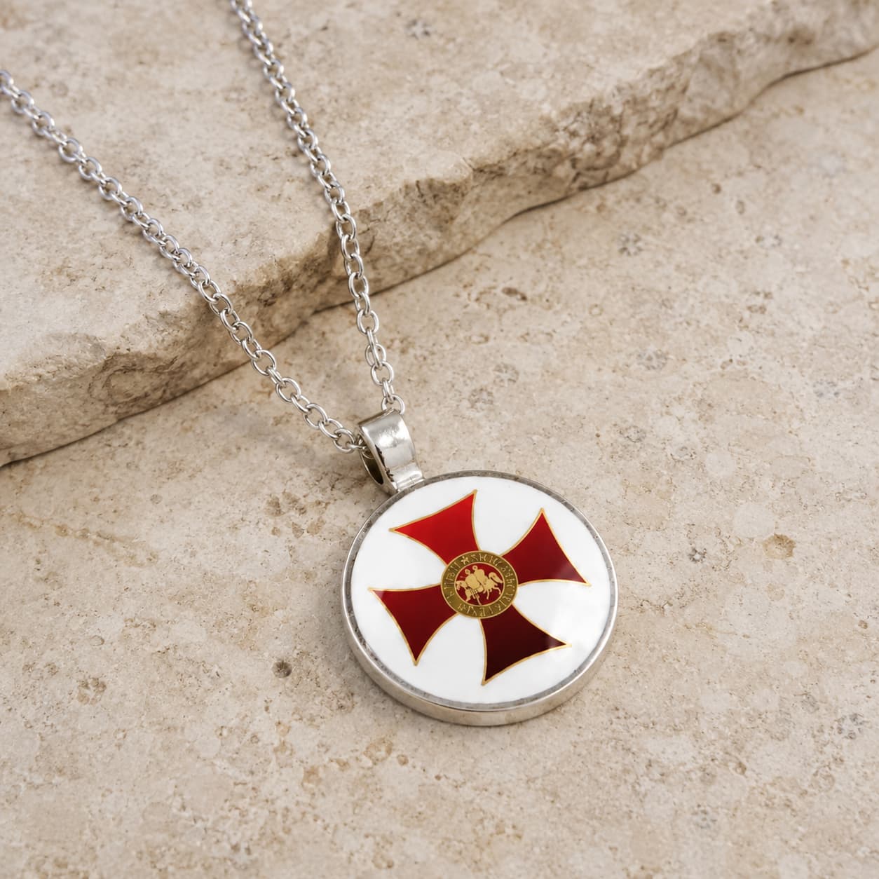 Collier des Emblèmes du Temple en alliage métallique avec pendentif croix rouge en vue angle 3/4 sur pierre médiévale claire