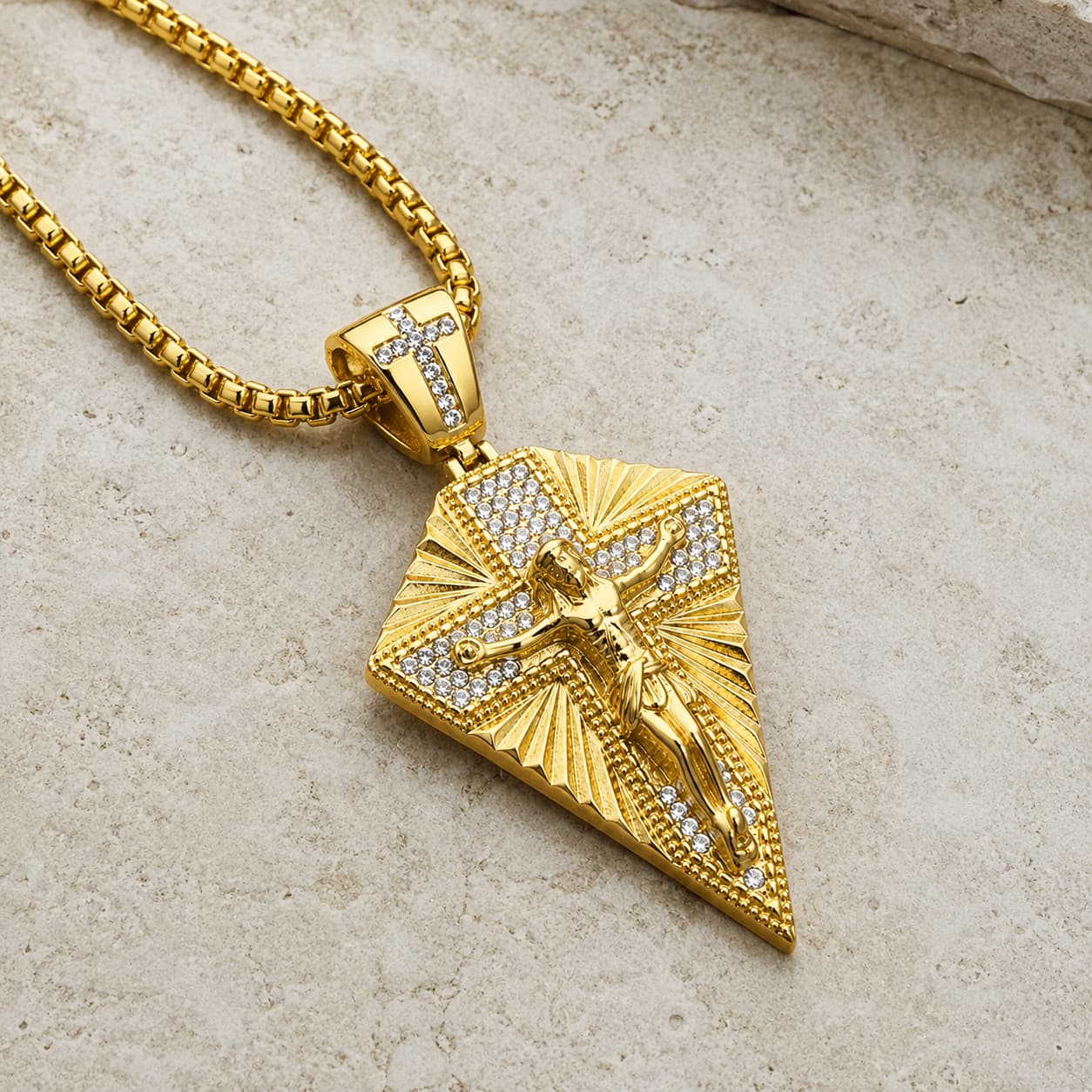 Vue angle 3/4 du Collier du Christ Sacré en acier inoxydable doré avec zircon cubique sur pierre médiévale claire.
