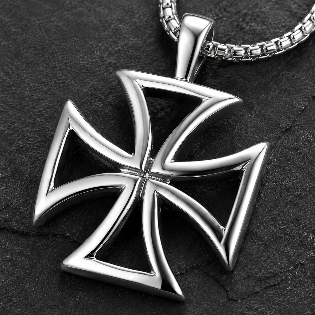 Gros plan de la croix templière argentée du Collier du Code d’Honneur en acier inoxydable sur fond anthracite