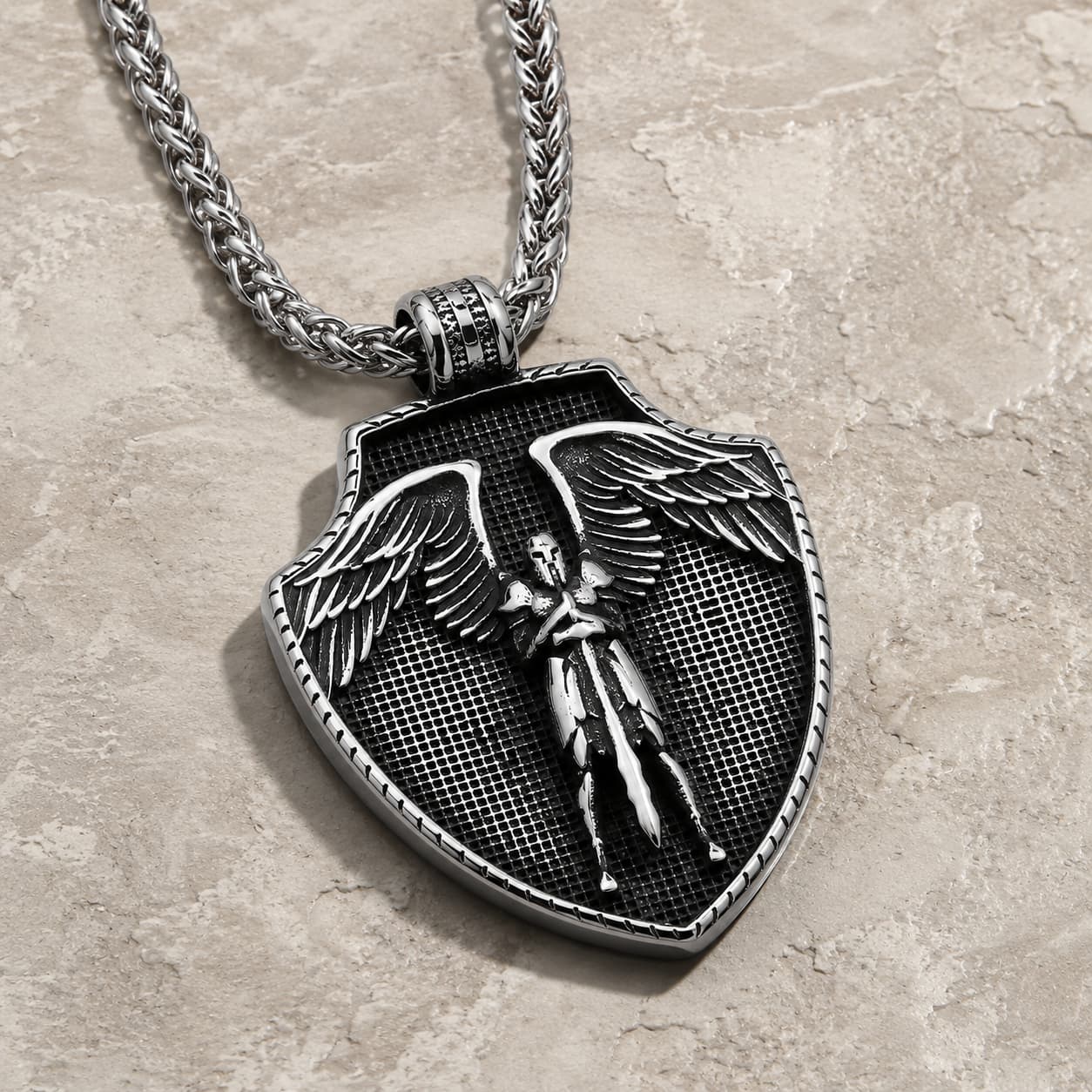 Vue angle du collier Collier du Pouvoir de l'Archange en acier inoxydable sur pierre médiévale claire
