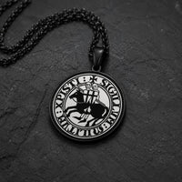 Collier du Sceau des Chevaliers en acier inoxydable noir avec pendentif sceau templier en vue angle 3/4 sur ardoise sombre