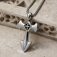 Vue angle du Collier de l’Épée Sacrée en acier inoxydable sur pierre médiévale claire