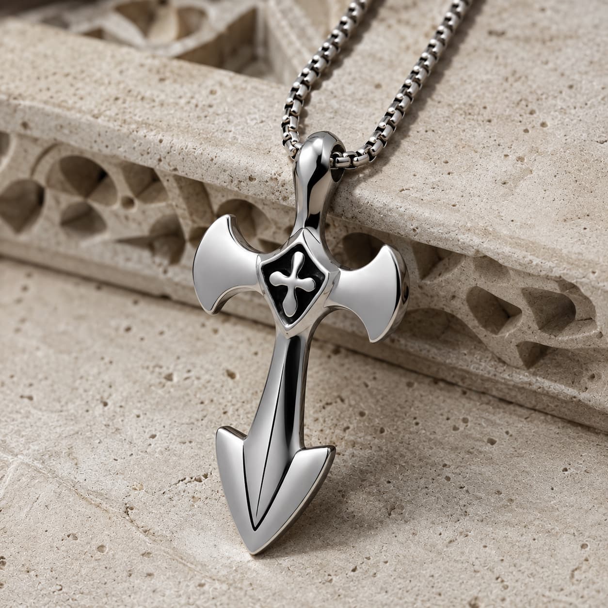 Vue angle du Collier de l’Épée Sacrée en acier inoxydable sur pierre médiévale claire