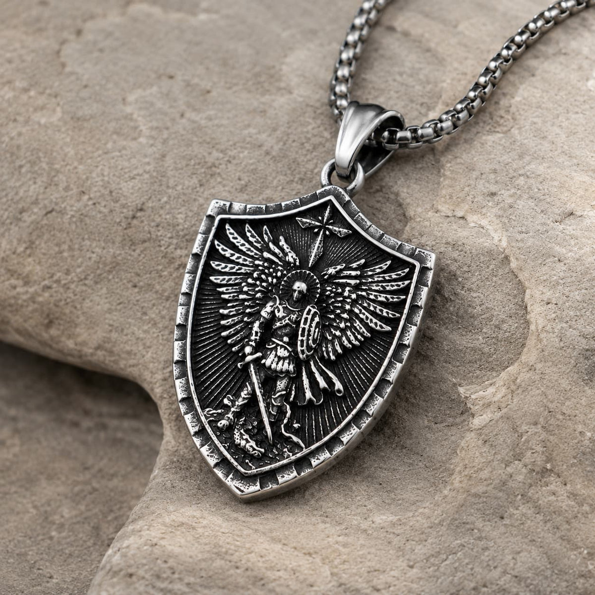Collier Force de l’Archange Michel en acier inoxydable vue angle 3 4 sur pierre médiévale claire