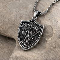 Collier Force de l’Archange Michel en acier inoxydable vue angle 3 4 sur pierre médiévale claire