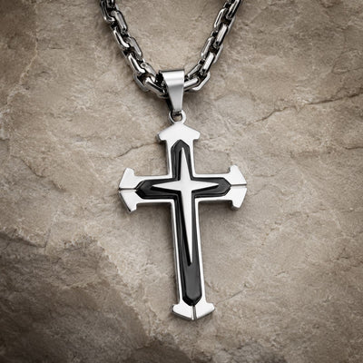 Collier du Gardien du Temple en acier inoxydable noir et argenté sur fond pierre médiévale claire.